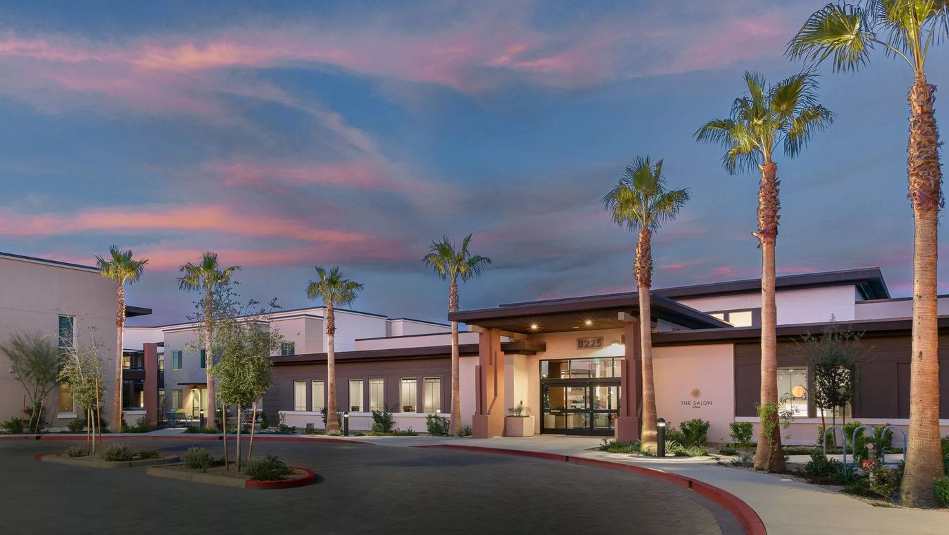 Exterior view of a senior living facility at sunset