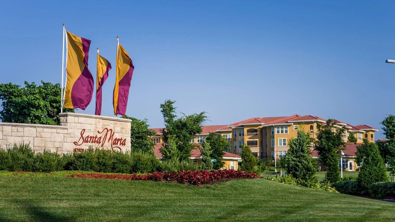 Entrance signage for Santa Marta with flags and landscaping