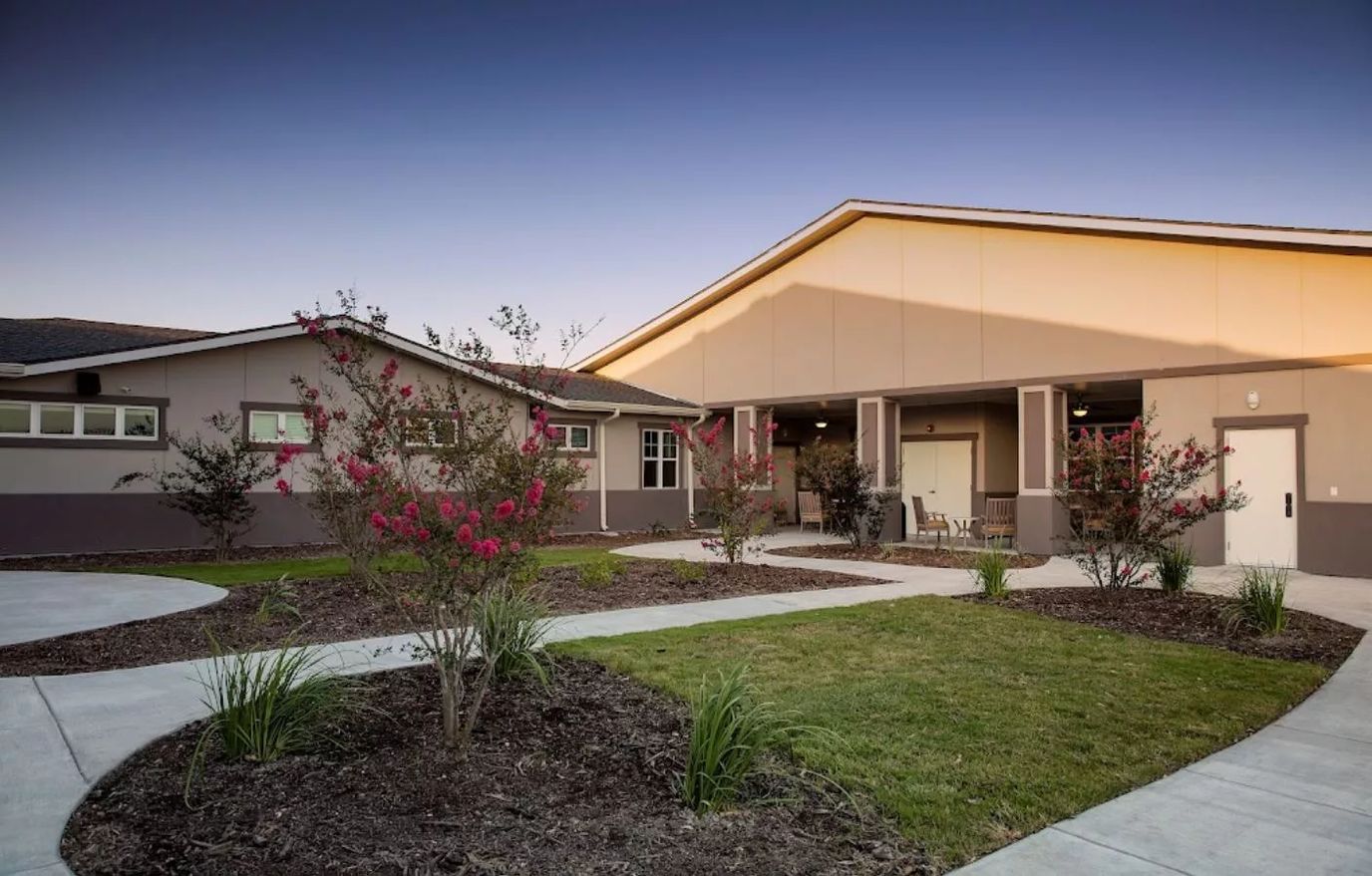 Exterior view of a senior living facility with landscaping