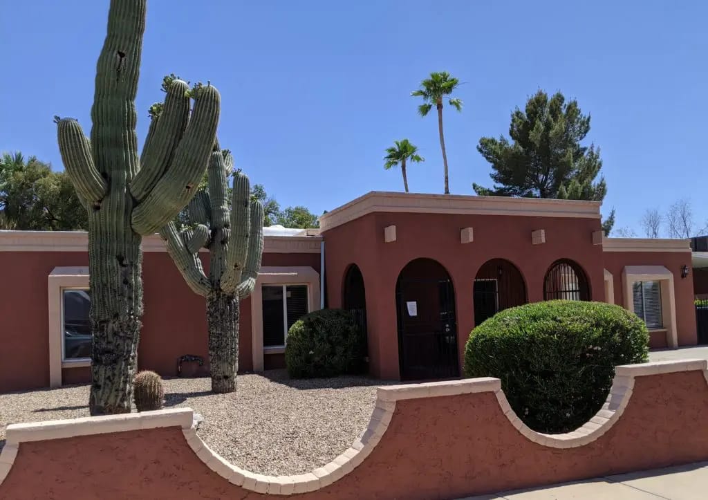 Exterior view of Starfish Care Homes with cacti and trees