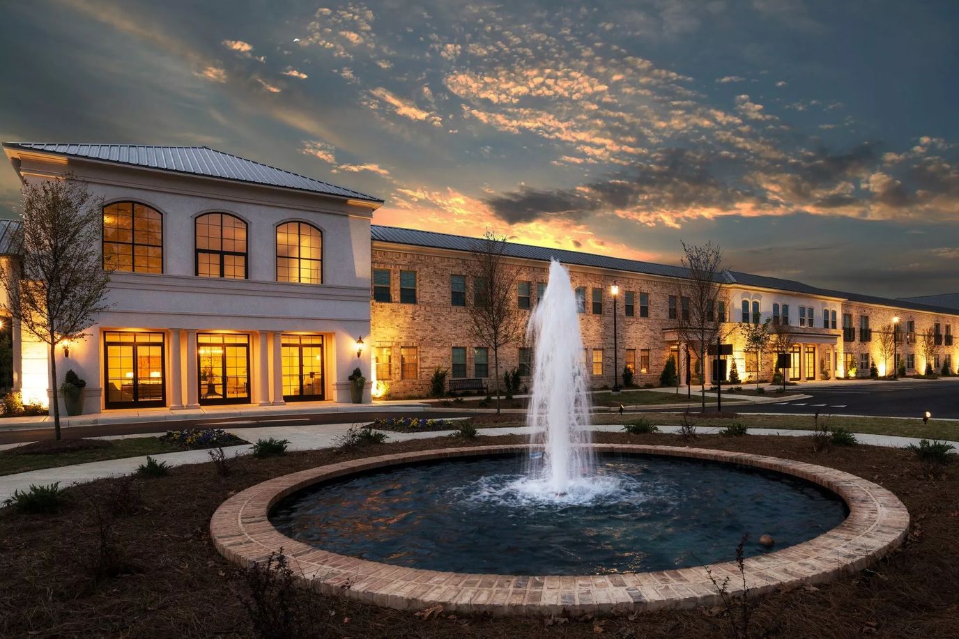 Exterior view of a senior living facility with a fountain