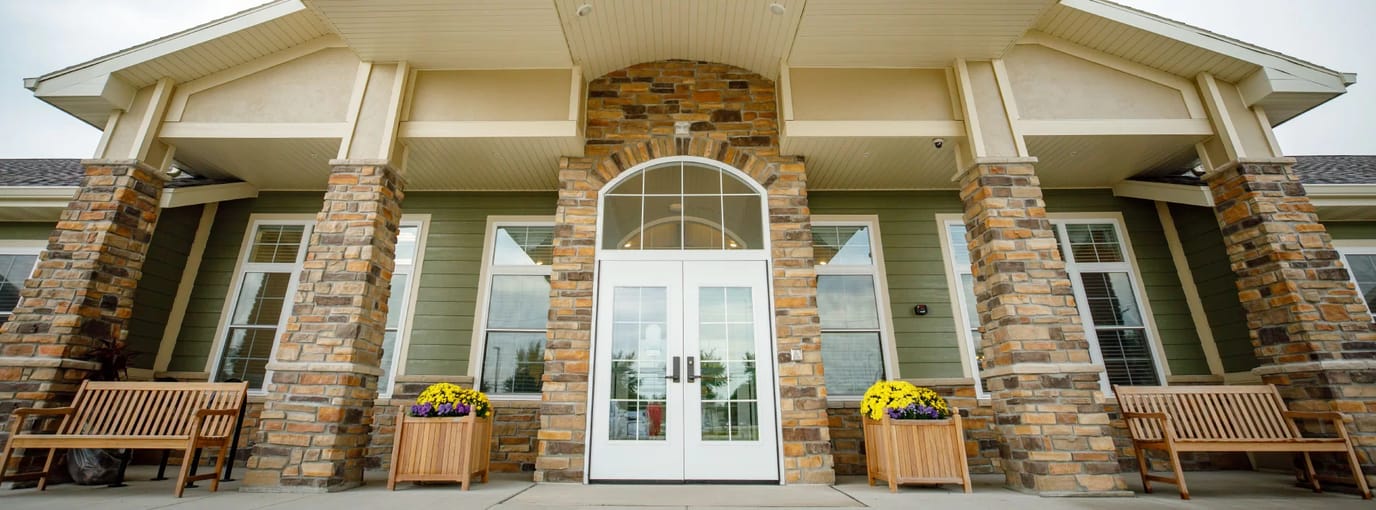 Front entrance of The Courtyard at Oshkosh with flower pots