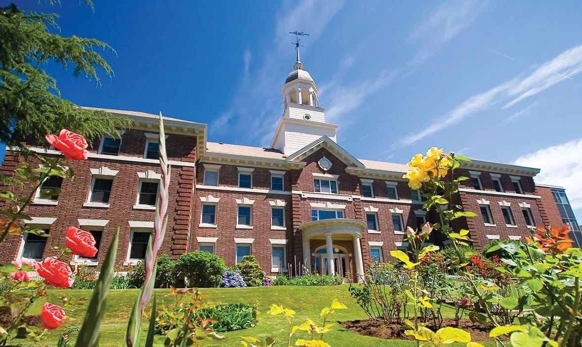 Exterior view of The Kenney with colorful flower gardens