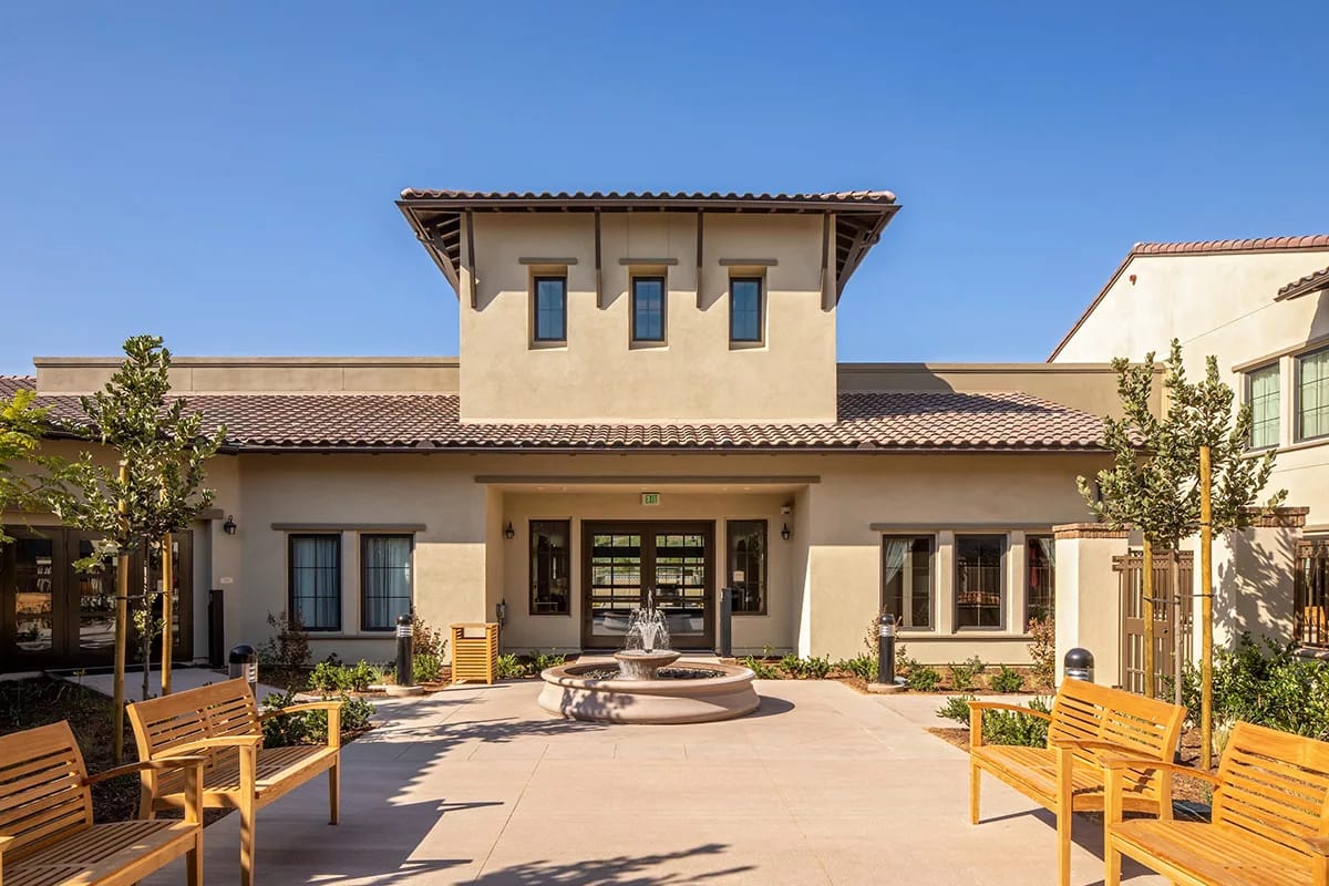 Exterior view of The Orchards Health Center with seating and fountain