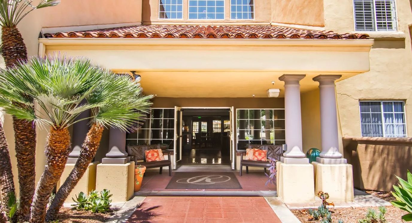 Entrance to The Remington Club Health Center with palm trees