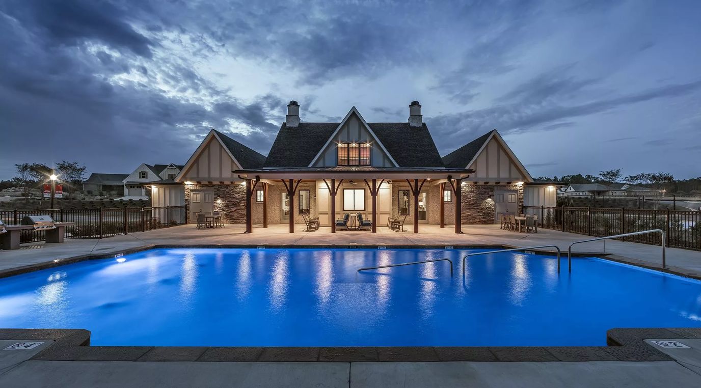 Exterior view of the facility with a pool at twilight