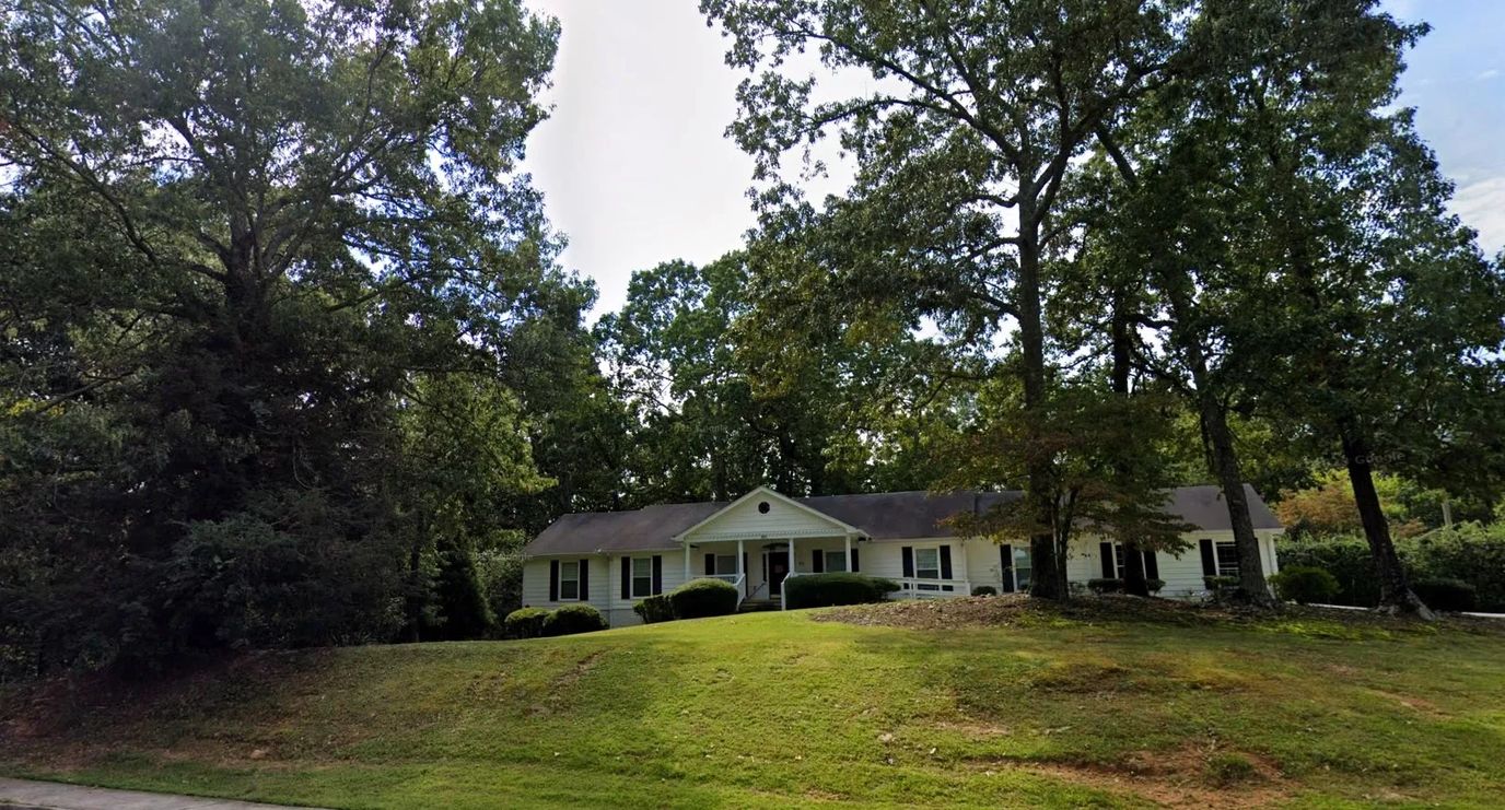 Exterior view of a residential building surrounded by trees
