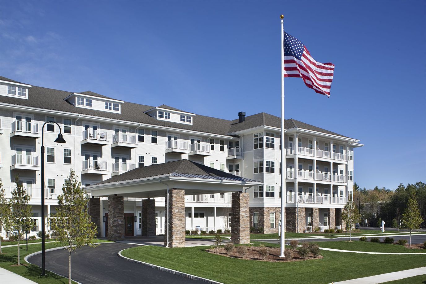 Exterior view of a senior living facility with flag