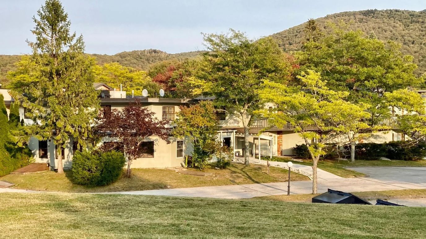 Exterior view of the facility surrounded by trees and hills