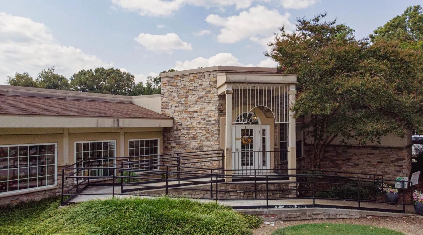 Exterior view of the facility with a ramp and landscaping
