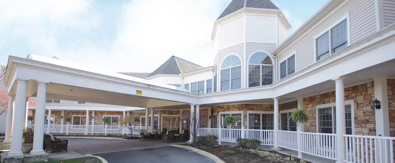Exterior view of a senior living facility with a covered entrance