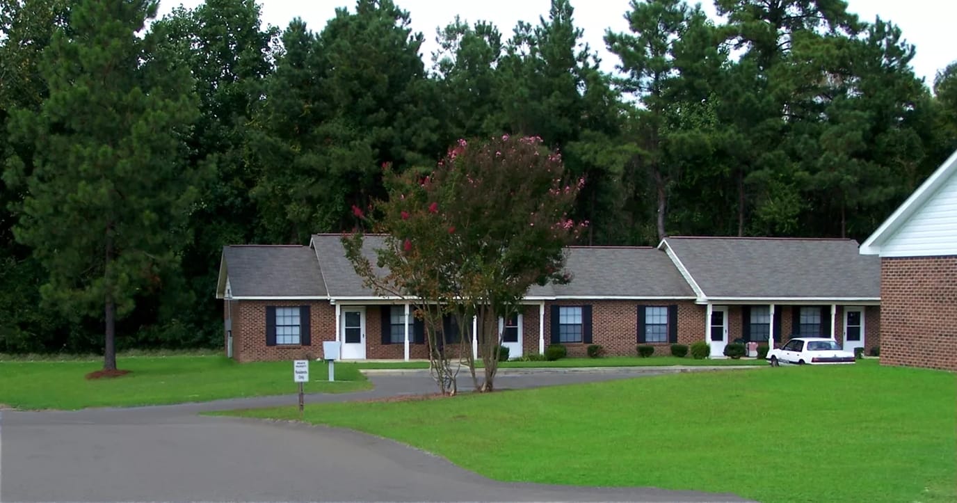 Exterior view of Fayetteville Manor with surrounding trees