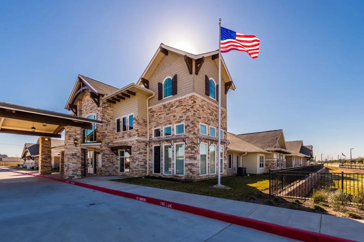 Exterior view of a senior living facility with an American flag