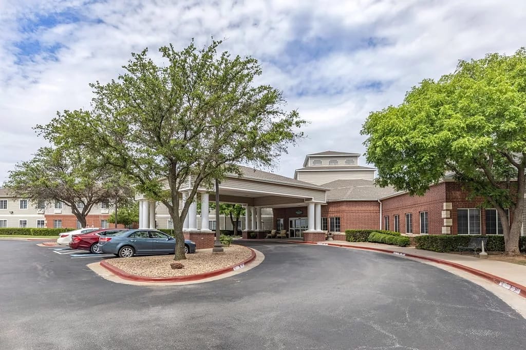 Exterior view of Royal Estates with trees and parking area