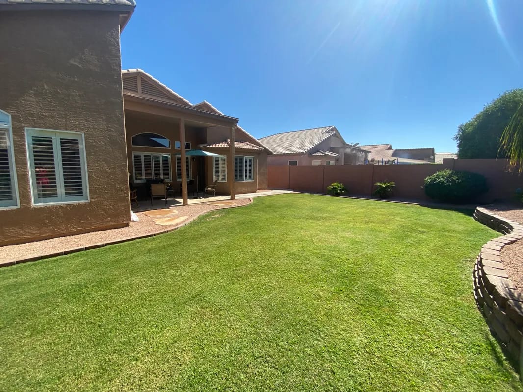 Well-maintained backyard with green lawn and patio area