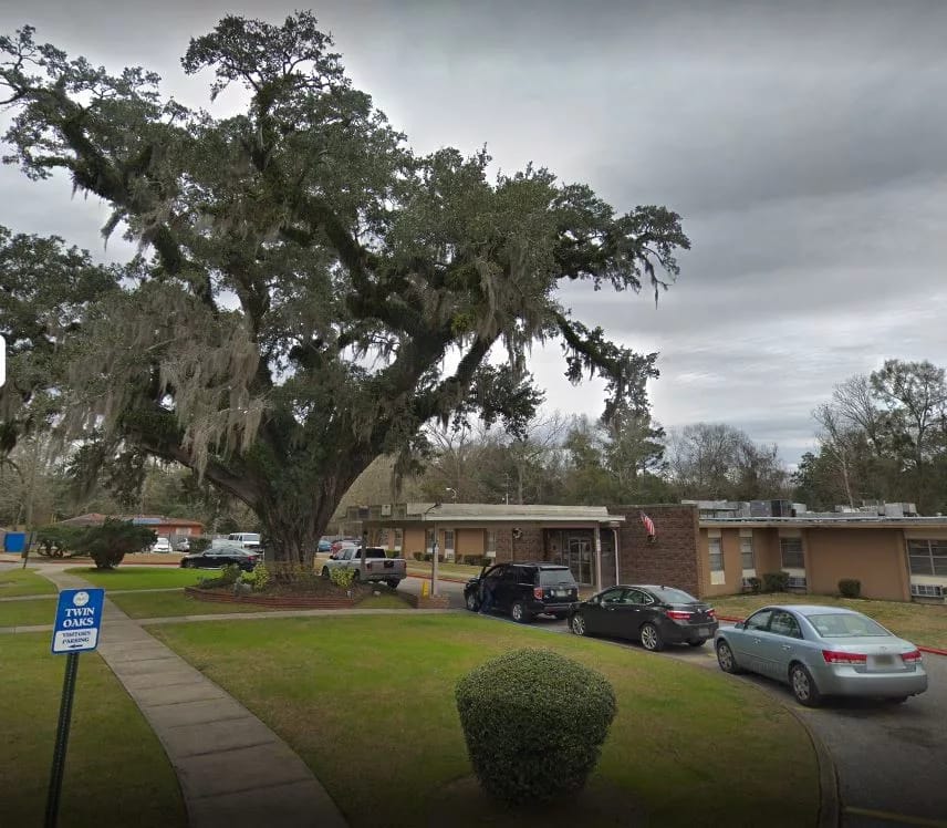 Exterior view of Twin Oaks facility with large tree