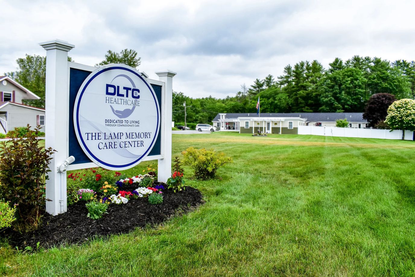 Exterior view of The Lamp Memory Care Center with sign and landscaping