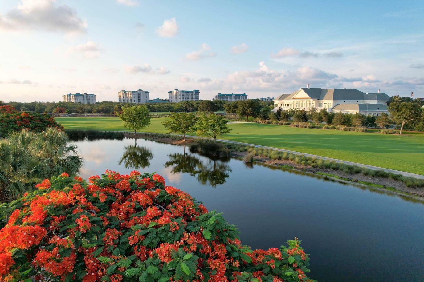 Aerial view of a retirement community with a pond and landscaping