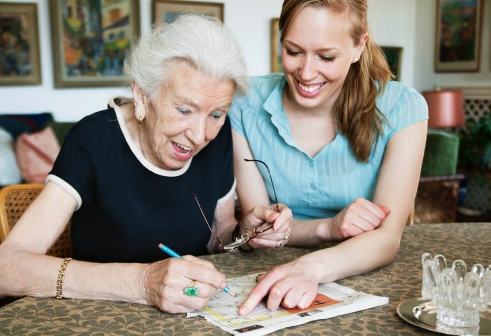 Senior resident and caregiver engaged in an activity.