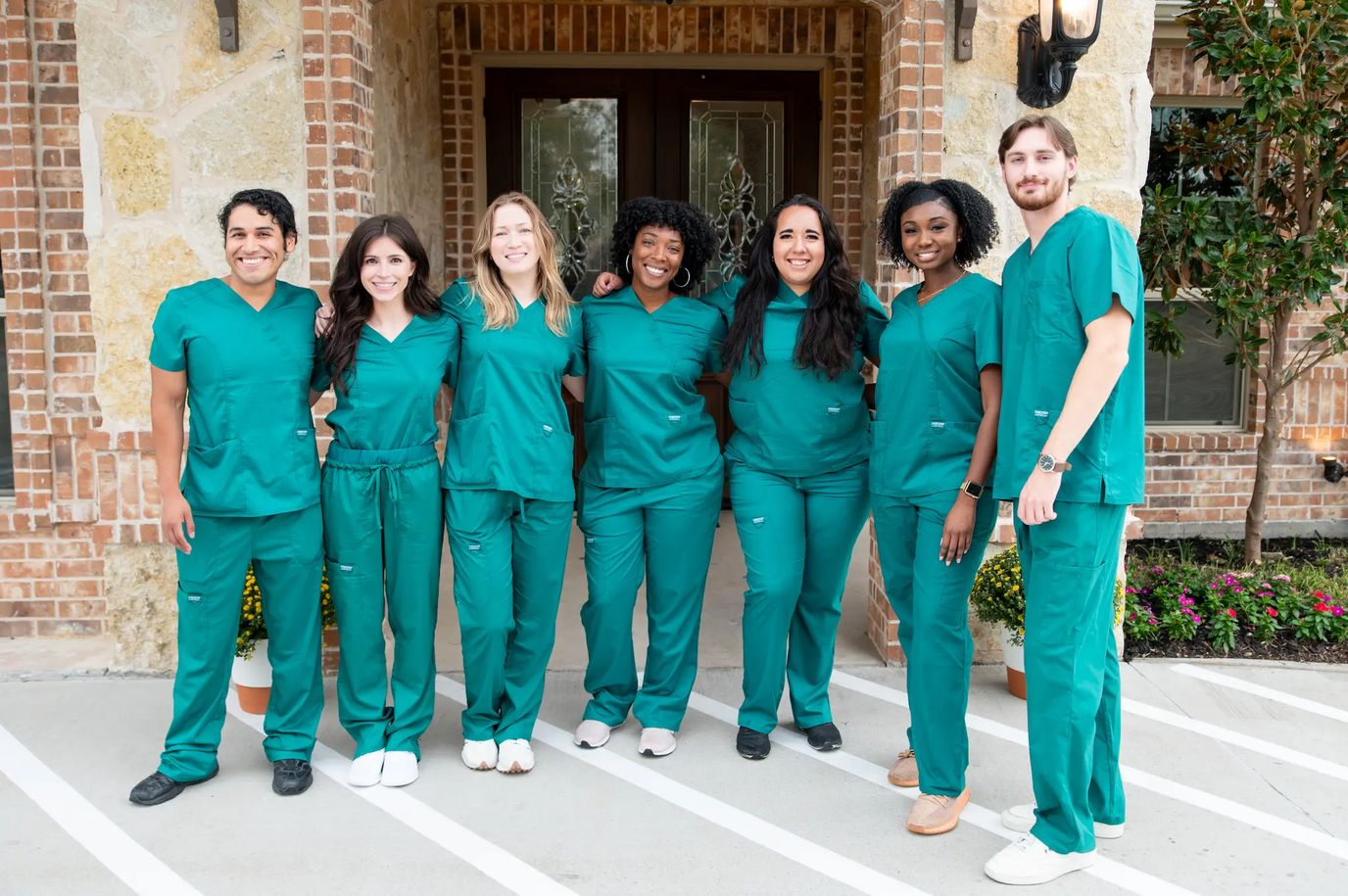 Staff members in green scrubs at facility entrance