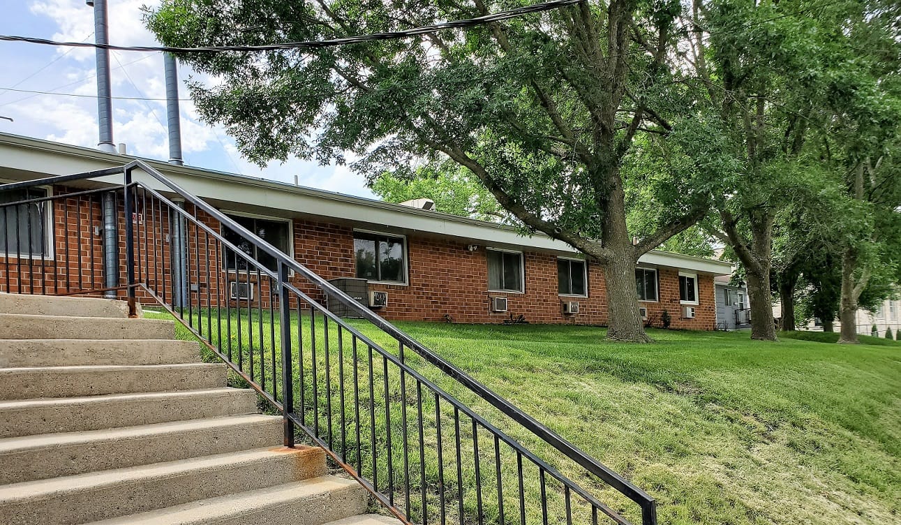 Exterior view of a senior living building with trees