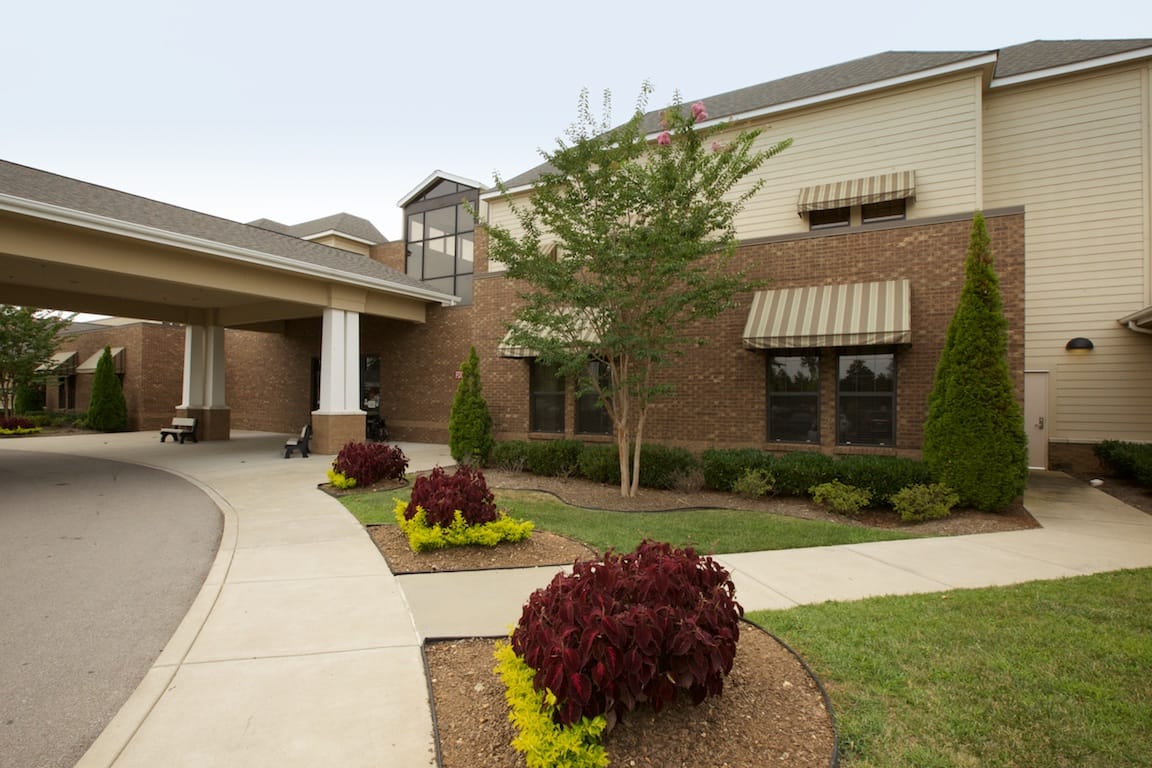 Exterior view of a senior living facility with landscaped garden