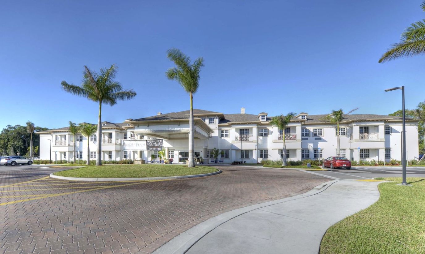 Exterior view of the Beach House facility surrounded by palm trees