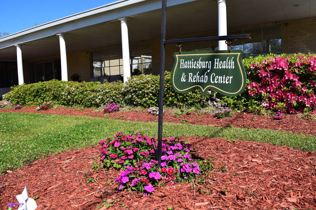 Sign for Hattiesburg Health & Rehab Center in front of flowers