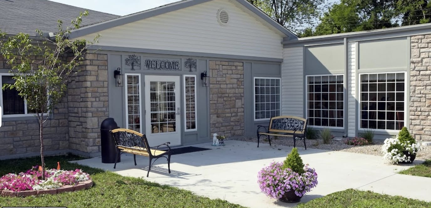 Exterior view of the facility entrance with benches and flowers