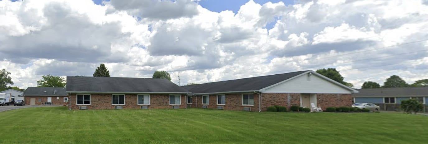 Exterior view of a senior living facility with green lawn