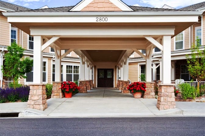 Front entrance of a senior living facility with landscaped approach
