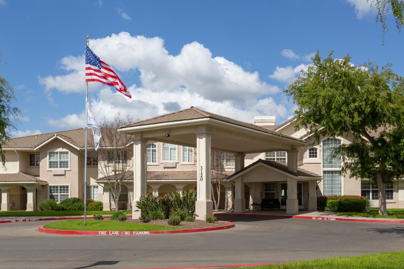 Entrance of Prestige Assisted Living at Visalia with flag