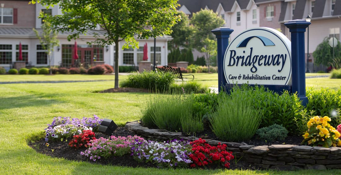 Outdoor sign and landscaping at Bridgeway Care and Rehabilitation Center