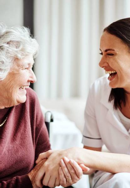Caregiver and senior resident sharing a joyful moment