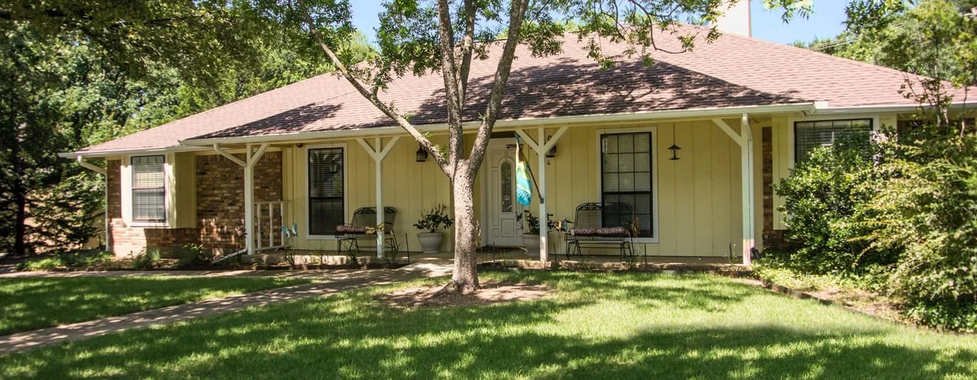 Exterior view of a senior living facility surrounded by trees
