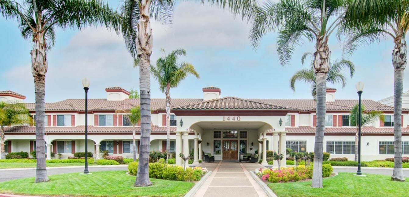 Front entrance of Aegis Living Shadowridge facility with palm trees