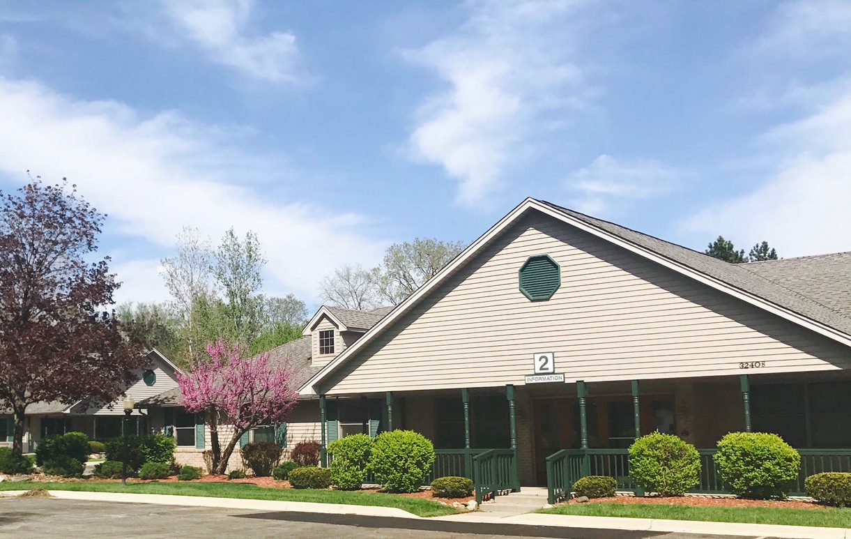 Exterior view of Aspen Assisted Living facility with landscaping