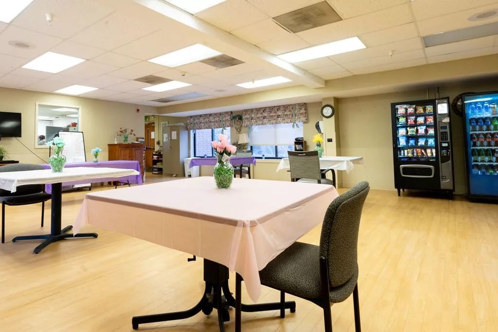 Bright common area with tables and a vending machine