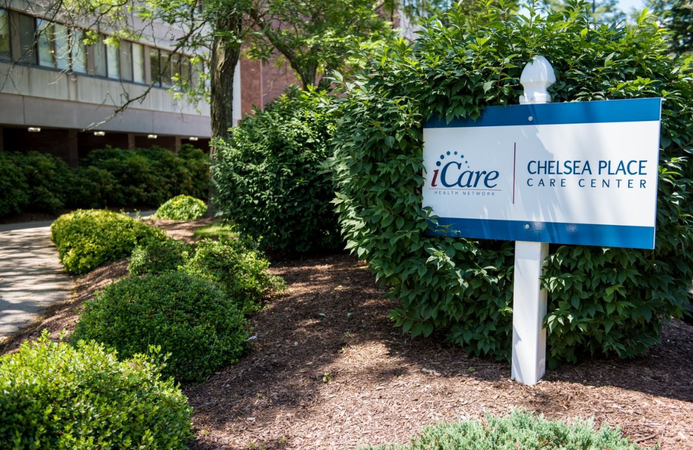 Exterior sign of Chelsea Place Care Center surrounded by greenery