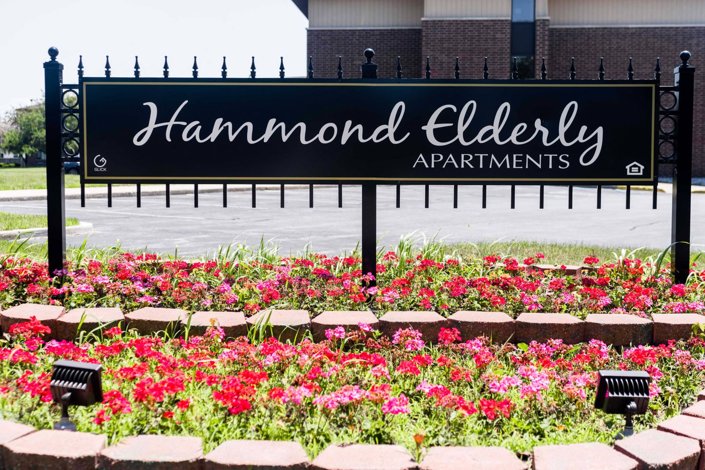 Sign for Hammond Elderly Apartments surrounded by flowers