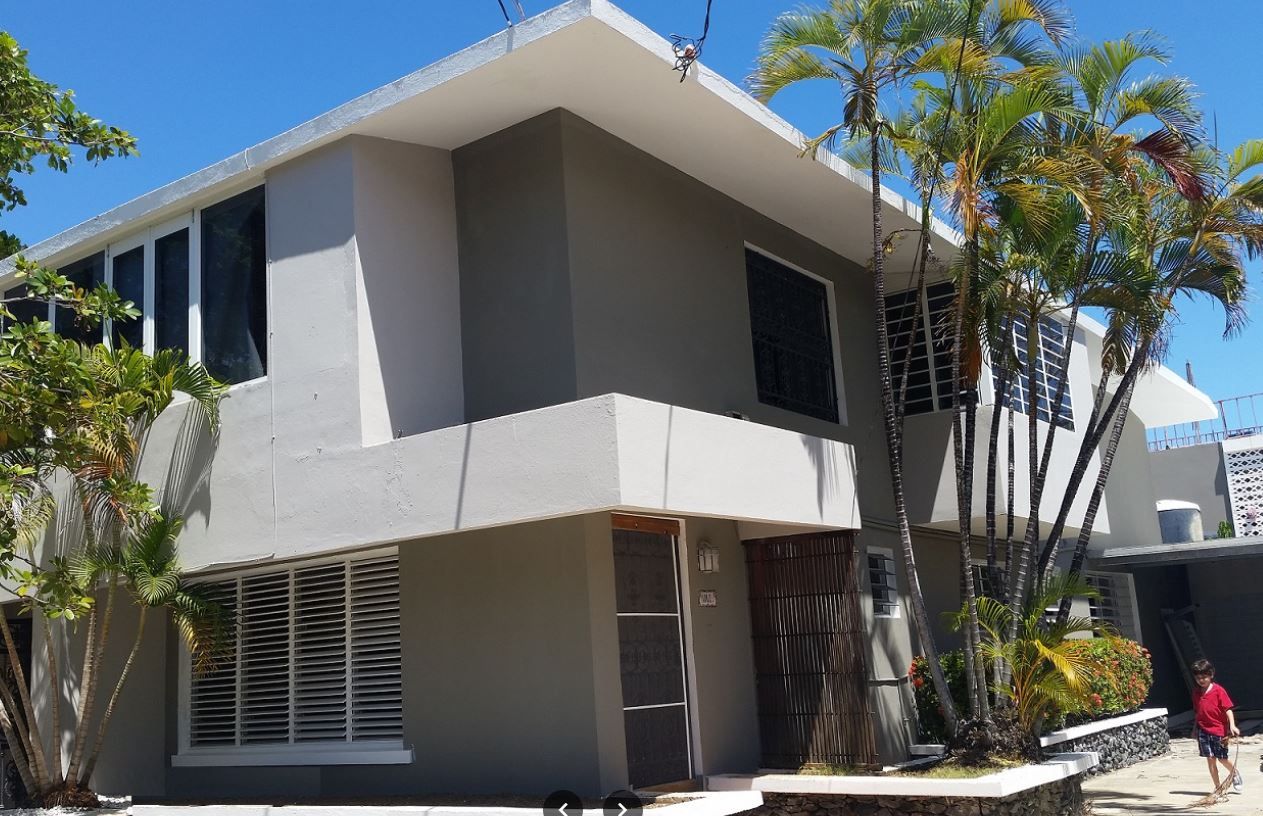 Exterior view of the facility building with palm trees