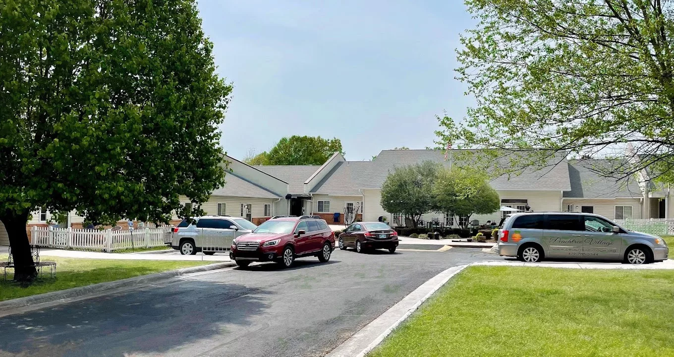 Exterior view of the Peachtree Village facility with parked cars
