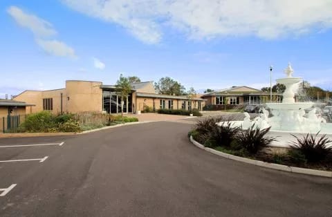 Exterior view of assisted living facility with fountain