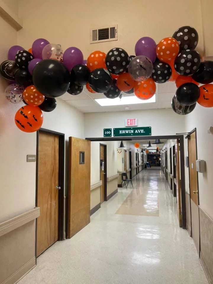 Decorative balloon arch in a facility hallway