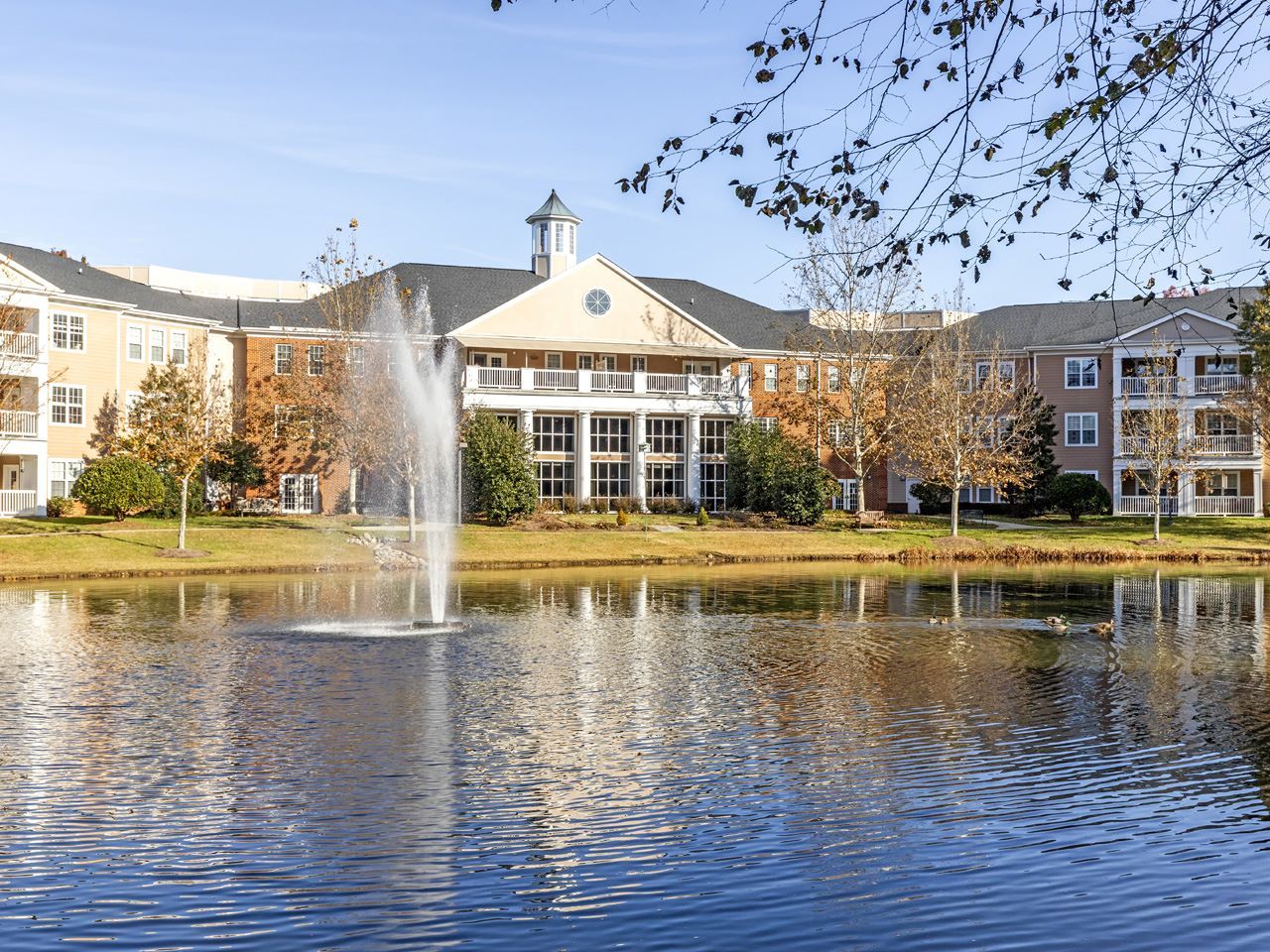 Exterior view of the facility by a pond with fountain