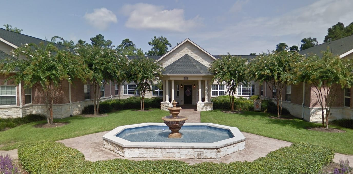Exterior view of a senior living facility with fountain