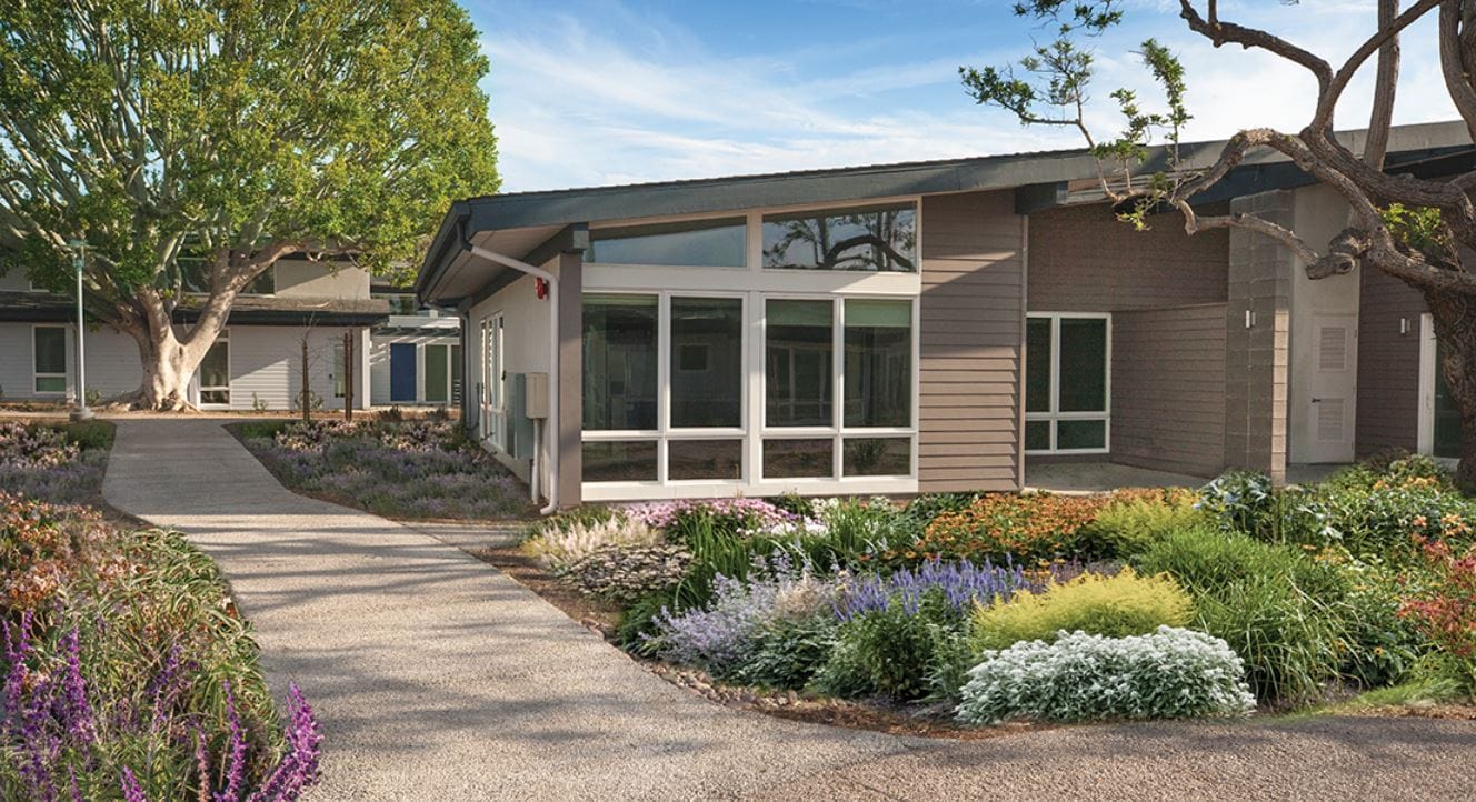 Exterior view of a senior living facility with gardens