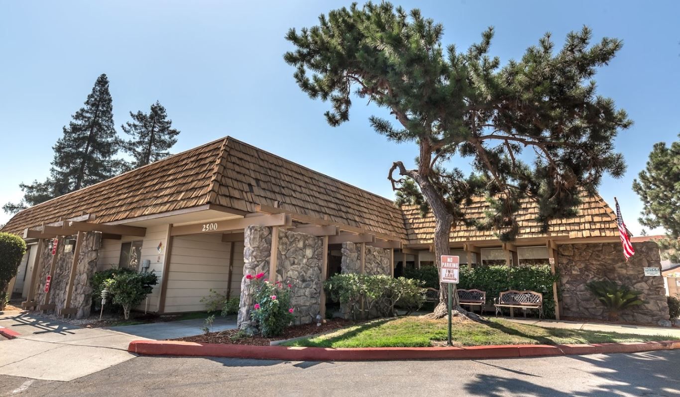Exterior view of a senior care facility with trees