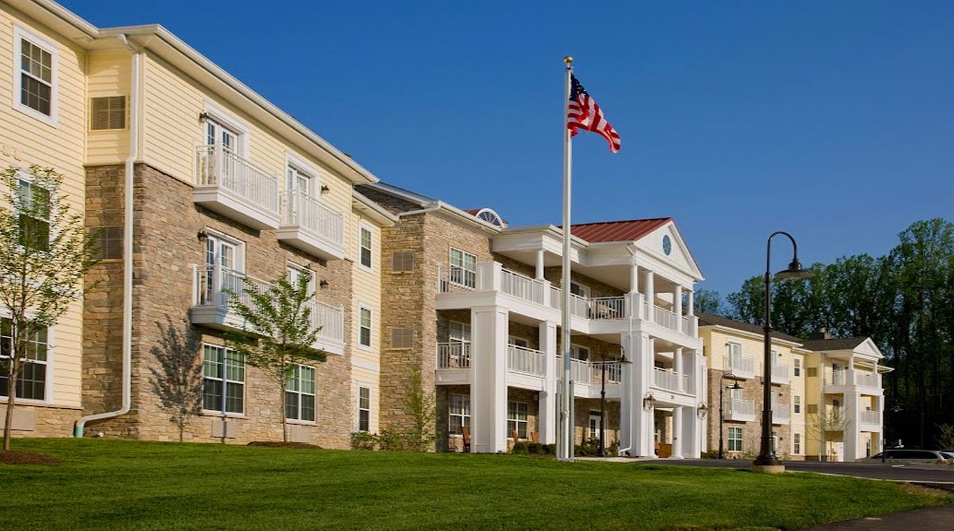 Exterior view of a senior living facility with a flag