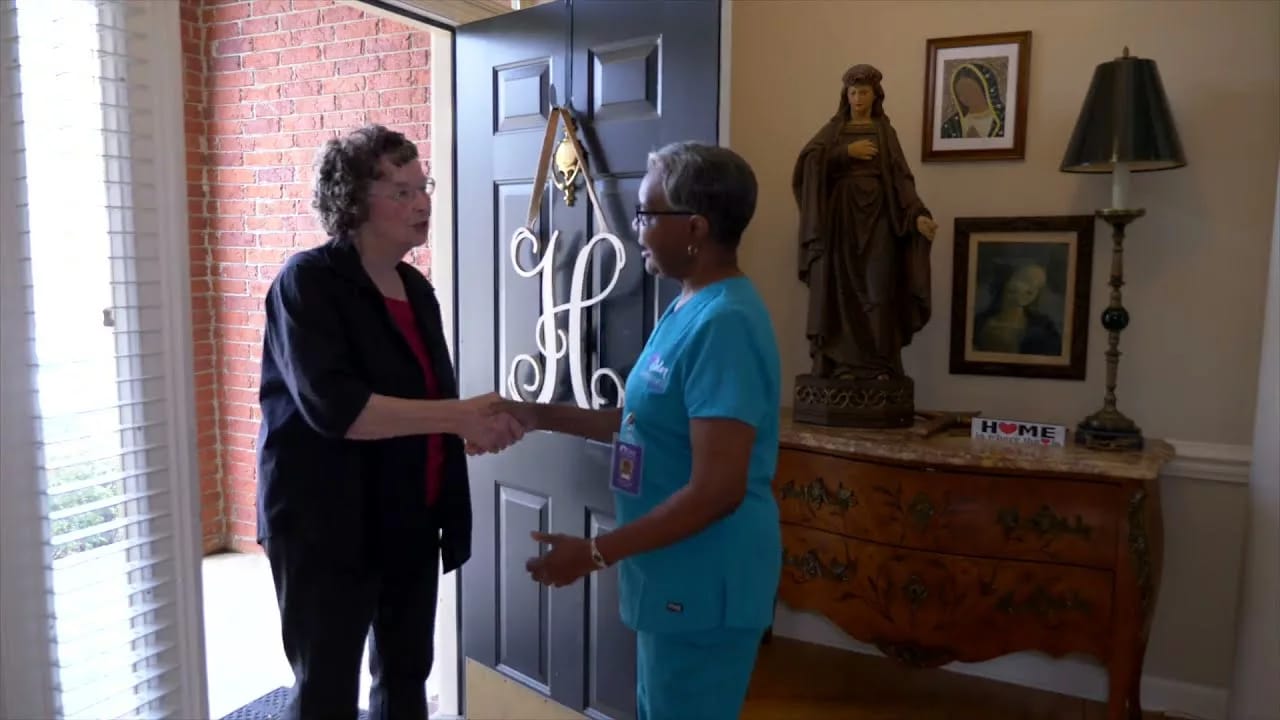 A staff member welcoming a visitor at the entrance